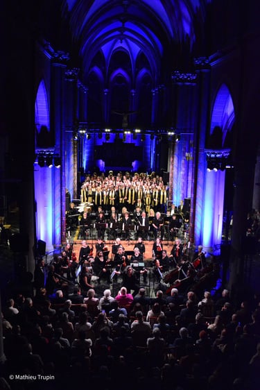 Photographie d'un concert de chorale et d'orchestre symphonique se déroulant à l'intérieur d'une église credit mathieu trupin