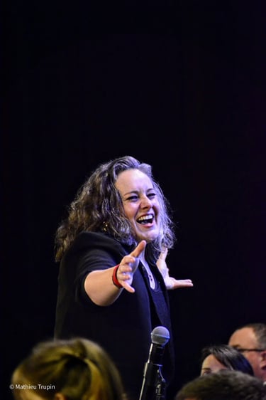 virginie humbert souriante sur scène les bras tendus
