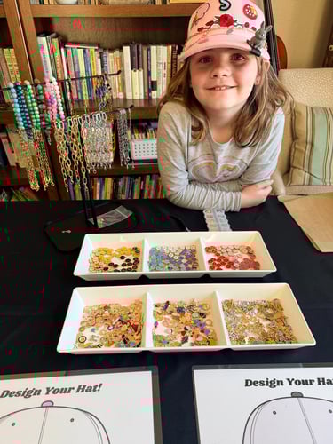 girl at a hat chain and charm display