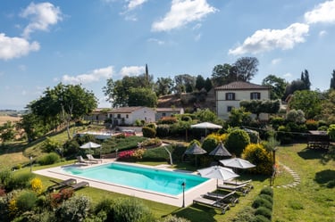 Luxury villa in Tuscany with an outdoor swimming pool, lounge chairs, and lush garden landscape.