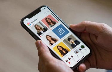 Close-up of a person's hands in a North American setting holding a smartphone, scrolling through a vibrant and professional Instagram feed.