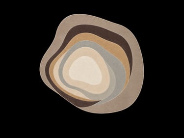 Modern abstract area rug with an organic layered pebble shape in neutral earth tones.