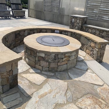 custom stone outdoor fireplace with stone seating area