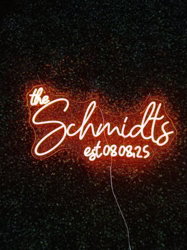 oranges LED Neon Schild „The Schmidts est. 08.08.25“ auf dunklem Hintergrund