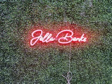 RGB LED Neon Namensschild Jella Berks personalisiertes Neon Schild auf grüner Pflanzenwand