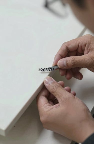 Detail shot of a artisan hand inspecting the edge of a custom-cut #2C3333 porcelain slab, emphasizing precision and quality.