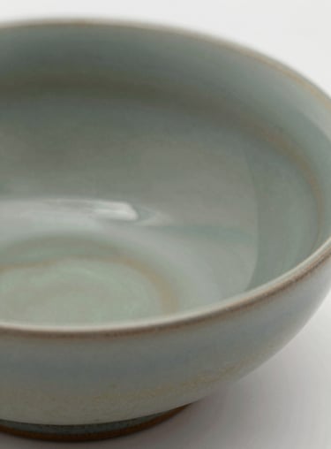 Macro photography of a unique ceramic glaze in shades of #597E52, showcasing the depth and artistic texture of the brand's surfaces.