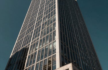 A wide angle photography of a modern Brazilian financial district building facade with geometric glass patterns reflecting a deep dark teal sky.
