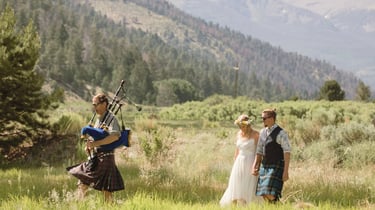 Couple with bagpiper in summer