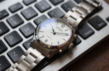 A macro photograph of a high-end keyboard and a sleek professional watch resting on a desk, symbolizing punctuality, meticulous attention to detail, and reliability.