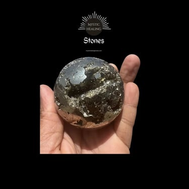 Polished pyrite sphere crystal held in hand showing a natural metallic cluster geode center.