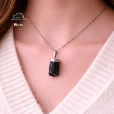 A woman wearing a raw black tourmaline crystal pendant necklace for protection and grounding.