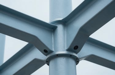 A macro shot of a metallic structural joint in a modern building, showing precision engineering in Soft Mist Blue light.