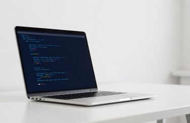 Minimalist representation of software development: a single, high-end laptop on a white desk with blue code reflection on the screen. Clean, bright #F5F5F5 environment with deep #1C1C1C contrasts.