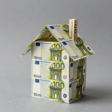 A house model constructed from 100 Euro banknotes representing real estate investment and mortgage costs.
