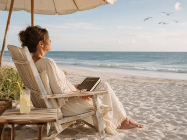 A woman relaxing on a beach chair under an umbrella reading the Holy Bible by the ocean.