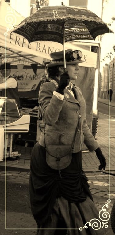 Woman in Victorian steampunk costume with goggles and a lace parasol at an outdoor market.