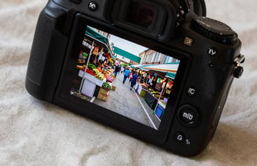 A high-quality close-up of a digital camera displaying a photo of a modern food market in North American / US, resting on a Crisp Parchment linen cloth.