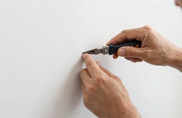 A close-up of a craftsman's hands using professional tools to finish a wall with perfect precision. The shot emphasizes meticulous craftsmanship and manual skill, with a palette of #455A64 and #ECEFF1.