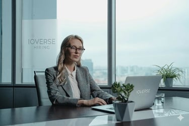 Professional female recruiter working at a desk with an Ioverse Hiring laptop in a modern office.