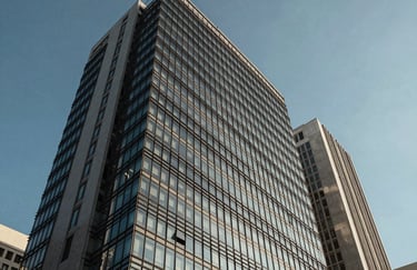 A modern office building facade in the heart of São Paulo, featuring glass and steel under a clear blue sky.