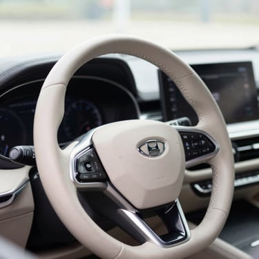 Close-up of a clean leather steering wheel and dashboard of a modern premium car, soft natural daylight, professional editorial style