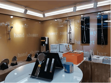 Showroom display featuring modern chrome hand showers and rainfall shower heads for bathroom renovations.