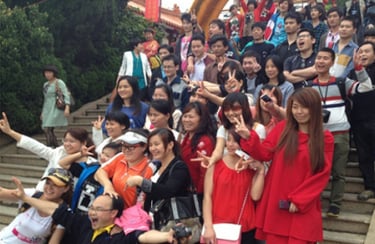 Staff of Cooldbath enjoy teambuilding of posing for a group photo on outdoor stairs during vacation