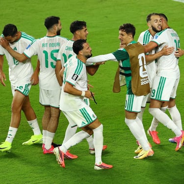 Algeria national football team players celebrating a goal on the pitch during a match.