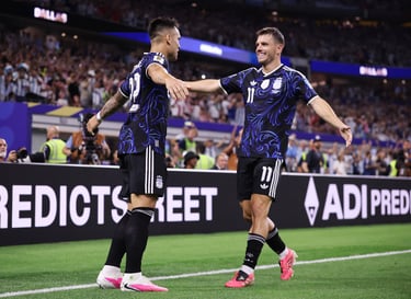 Argentina soccer players in black jerseys celebrate a goal on the field at a stadium.