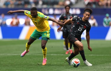 Two soccer players compete for the ball during an intense international match on a green field.