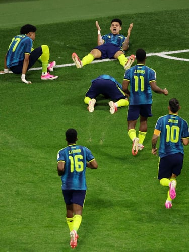 Colombia national football team players celebrating a goal on the grass during a match.