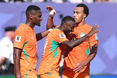 Ivory Coast national football team players celebrating a goal in orange kits.