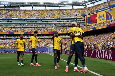 Ecuador national football team players celebrate a goal in a packed stadium during a FIFA World Cup 2026 match.