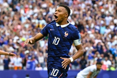French soccer player Kylian Mbappe celebrates a goal in a blue jersey on the field.