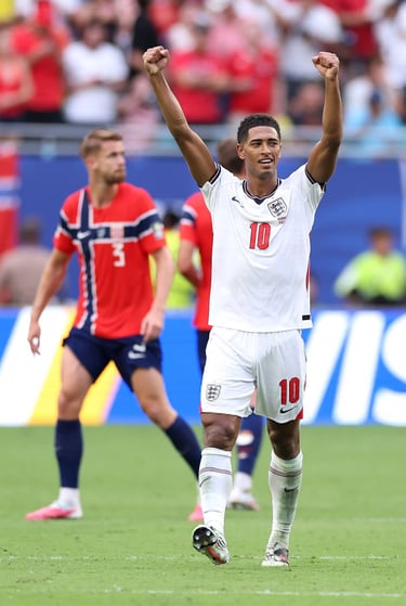 England midfielder Jude Bellingham celebrating a goal with raised arms during a football match.