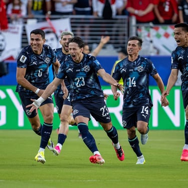 Paraguay national football team players celebrating a goal on the pitch during a soccer match.