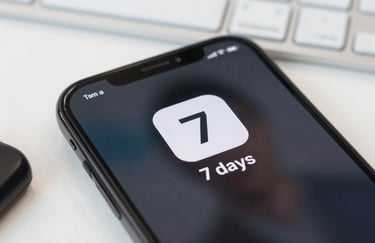 A close-up shot of a modern smartphone showing a '7 days' icon with a professional digital interface. Bright, clean Latin American office setting with soft white lighting.