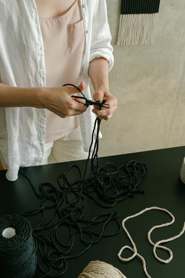 manos cortando hilo con unas tijeras 