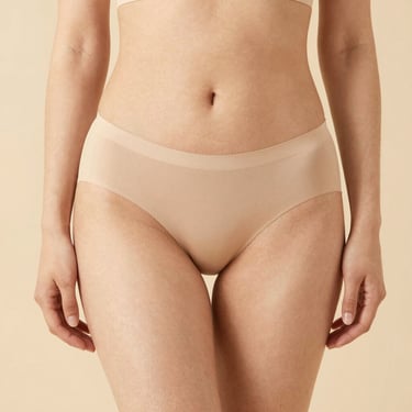 Rear view of a person wearing low-rise white bikini bottoms with moderate coverage.