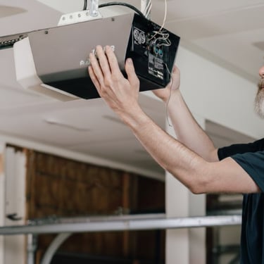 Professional technician performing a garage door opener repair and motor installation.