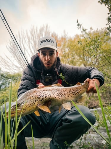 Pescador con gran trucha en un río de la montaña de León