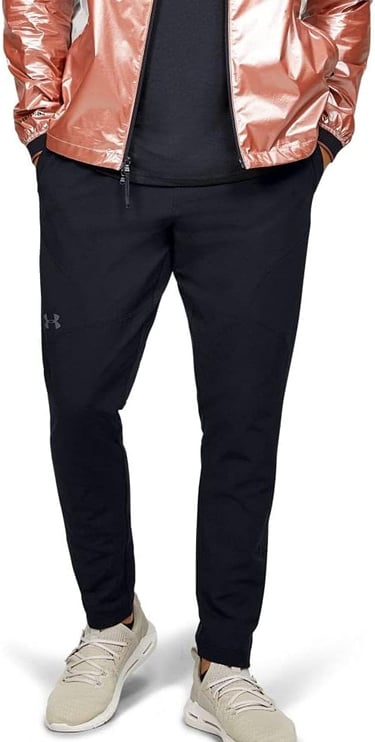 Modelo vestindo calça Under Armour azul marinho em tecido técnico de alta performance.