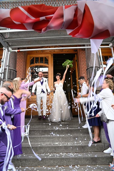 Hochzeitsfotograf am Möhnesee: Auszug des Brautpaares aus dem Standesamt unter Konfetti-Regen und weißem Bänder-Spalier.