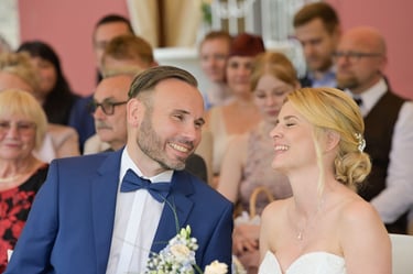 Hochzeitsfotograf Möhnesee: Brautpaar lacht herzlich während der Trauung; authentische Hochzeitsreportage voller Freude.