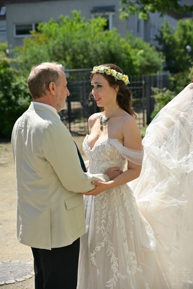 Hochzeitsfotograf Möhnesee: Emotionaler Moment, in dem der Vater die Hände der Braut hält; Brautkleid mit Blumenkranz.