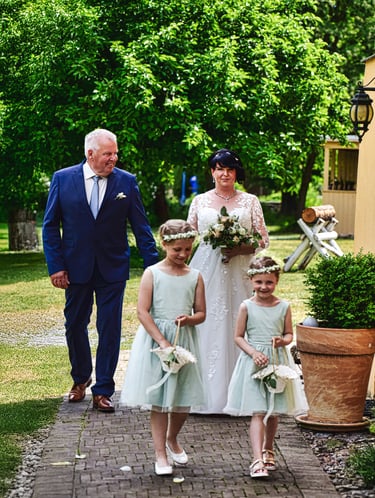 Braut beim Einzug zur freien Trauung im Garten am Möhnesee, begleitet von zwei Blumenmädchen.