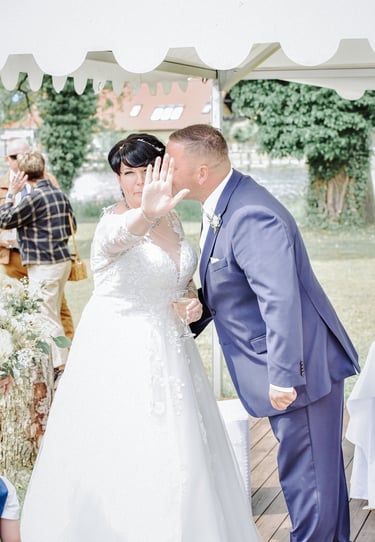 Braut und Bräutigam beim Sektempfang nach der Trauung am Möhnesee unter einem Pavillon.
