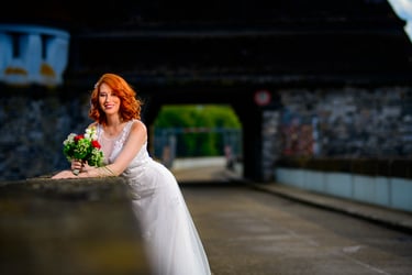 Braut lehnt sich mit Blumenstrauß an die Möhnetalsperre – emotionale Hochzeitsfotografie am Möhnesee.