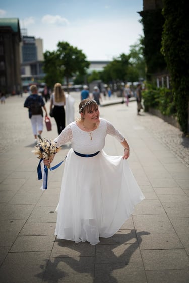 Glückliche Braut im weißen Kleid lacht während des Hochzeitstages – natürliche Hochzeitsfotografie am Möhnesee.